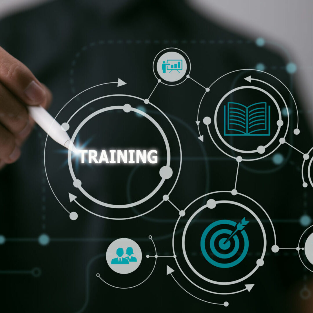 Webinar E-learning Skills Business Internet Technology Concepts Training Webinar E-learning Skills. A hand with a stylus points to a digital graphic featuring the word "TRAINING" surrounded by icons of people, a dartboard, a book, a head, and a graph, against a dark background.